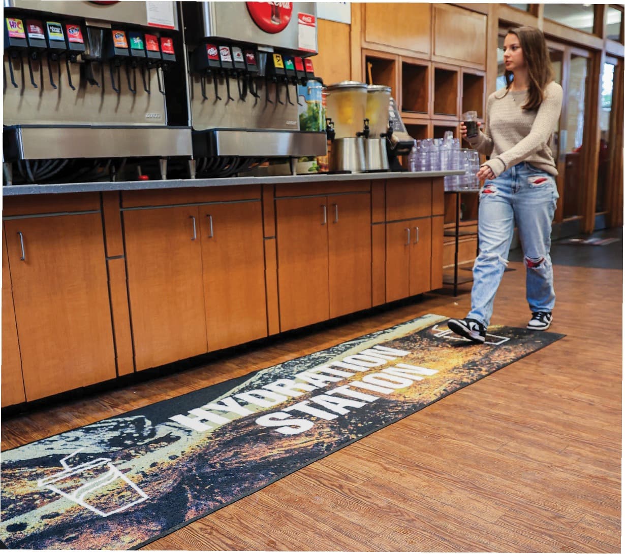 Branded Aviation Station floor runner placed along an interior beverage area